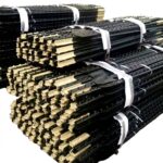 Bulk stacked black PVC coated Y steel fence posts tied bundles factory warehouse stock for wholesale farm fencing supply | ANJIA