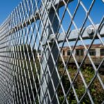 Hot dipped galvanized expanded metal mesh installed as outdoor industrial perimeter security fencing barrier | ANJIA