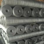 Bulk hot dipped galvanized square wire mesh rolls stacked in factory warehouse, ready for wholesale export and large-scale construction projects | ANJIA