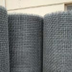 Three rolls of durable galvanized square wire mesh standing in warehouse, showcasing bulk inventory for OEM and construction supply orders | ANJIA