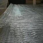 Bulk stacked galvanized triangle top wire mesh fence panels in factory warehouse for export wholesale supply | ANJIA