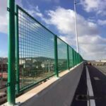 Powder coated steel frame welded wire mesh fence installed along highway bridge perimeter for traffic safety protection | ANJIA
