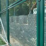 Close-up of green PVC coated steel framed chain link mesh fence, installed for sports field stadium perimeter safety protection | ANJIA