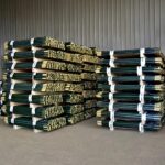 Bulk bundled green PVC coated steel star pickets (Y fence posts) stacked in factory warehouse for Australian farm pasture fencing wholesale supply | ANJIA