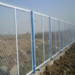 White and blue powder coated expanded metal frame fence installed on construction site slope for perimeter safety isolation | ANJIA