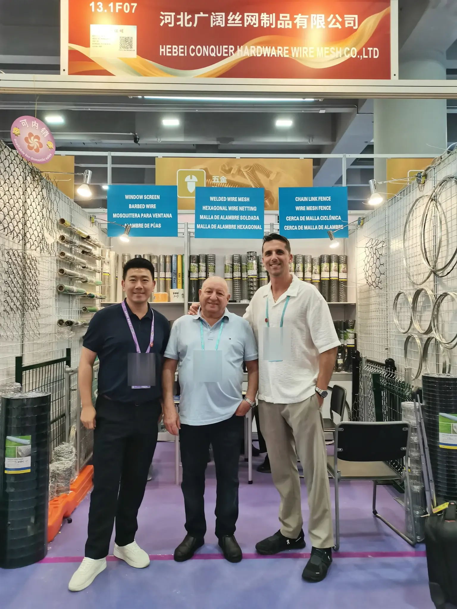 ANJIA team member and visitors beside wire mesh displays at Booth 13.1F07