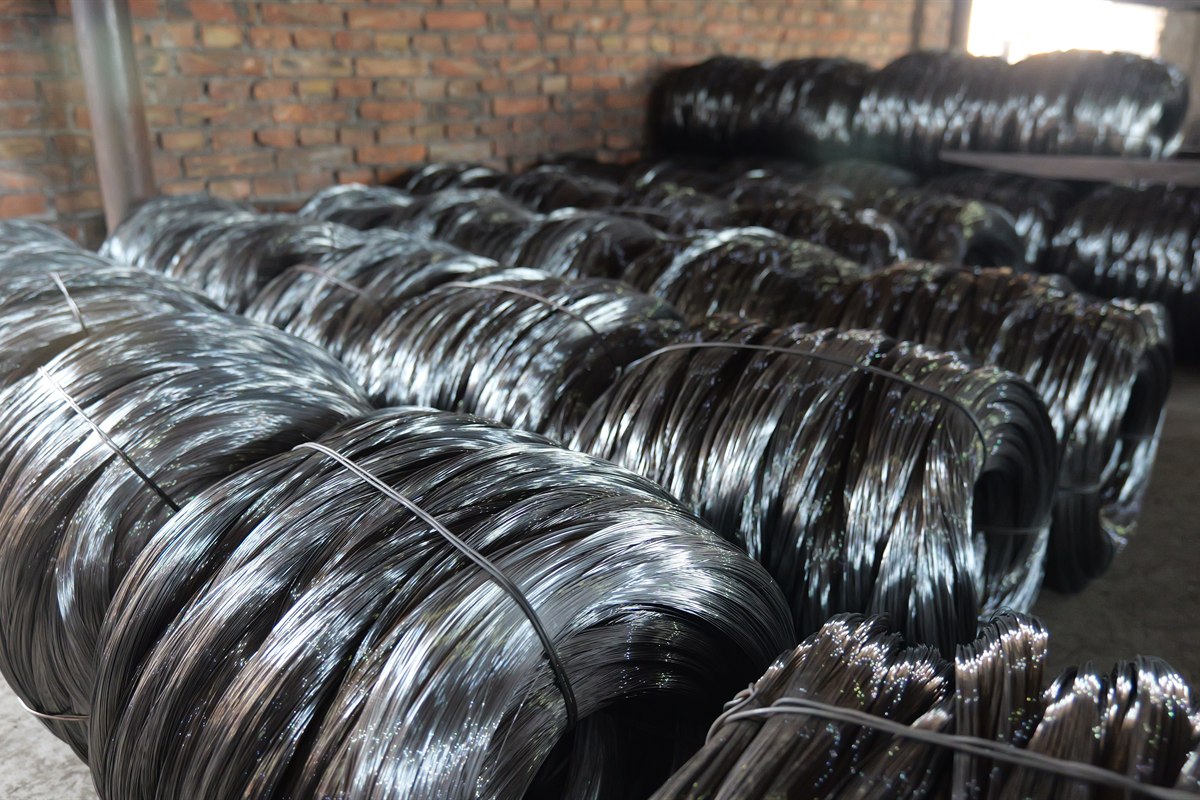 Bulk black annealed wire coils with dark surface finish prepared for factory storage and export packing